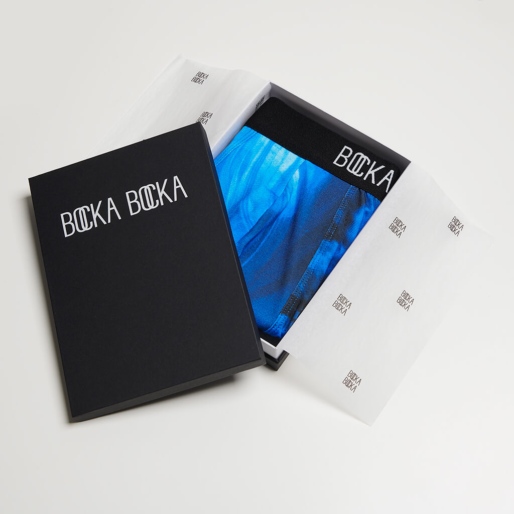 A pair of Bocka Bocka Onde Supernova mens designer trunks in a Bocka Bocka gift box